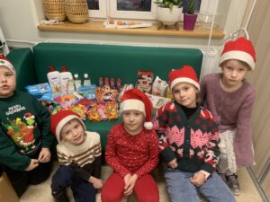Uczniowie klas 1 z prezentami zakupionymi do hospicjum ze środków ze sprzedaży pierniczków